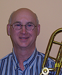 Tom smiling holding a trombone